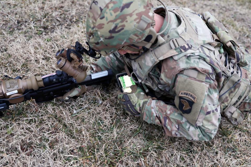 A soldier from the 101st Airborne Division checks his Nett Warrior end user device during a full mission test at Aberdeen Proving Ground, Maryland, in February 2021. (Justin Sweet/Army)