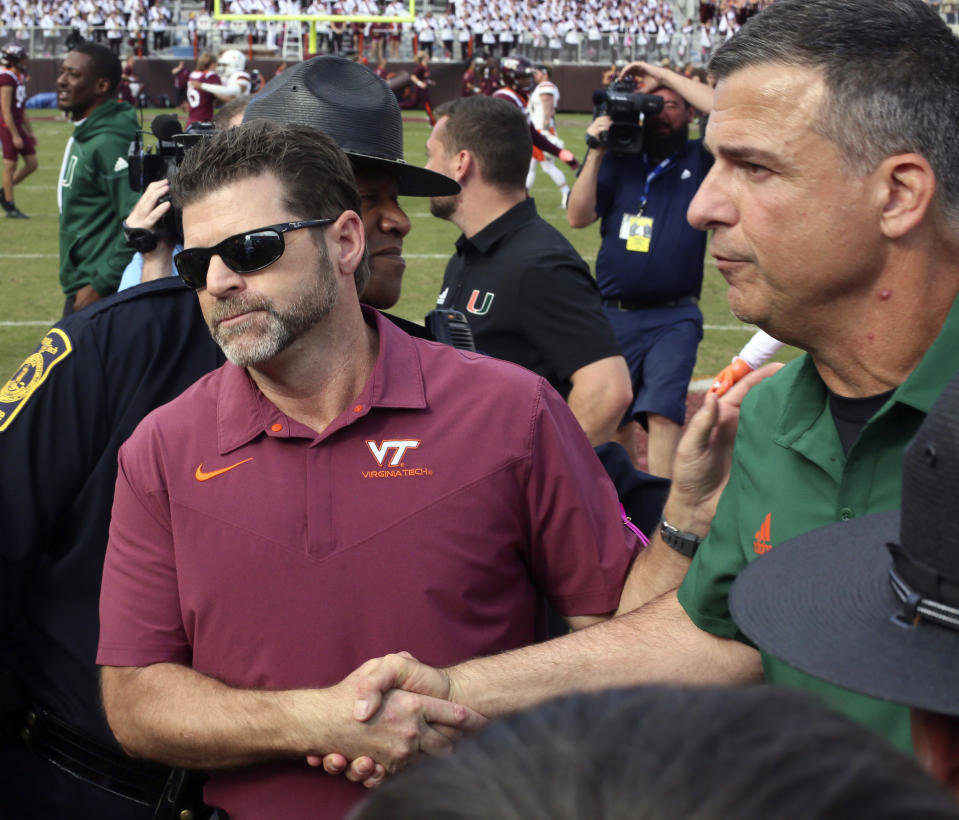 Virginia Tech head coach Brent Pry, left, and Miami head coach Mario Cristobal at midfield after an NCAA football game, Saturday Oct. 15 2022, in Blacksburg Va. (Matt Gentry/The Roanoke Times via AP)