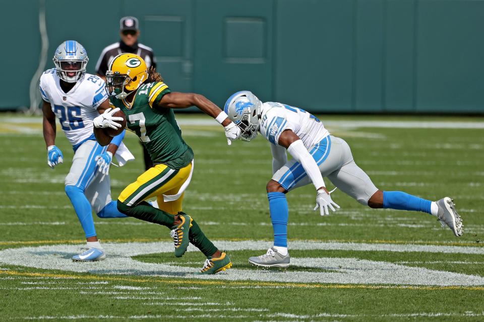 Davante Adams (17) of the Green Bay Packers runs with the ball while being chased by Duron Harmon (26) and Jeff Okudah (30) of the Detroit Lions in the second quarter at Lambeau Field on Sept. 20, 2020 in Green Bay, Wisconsin.