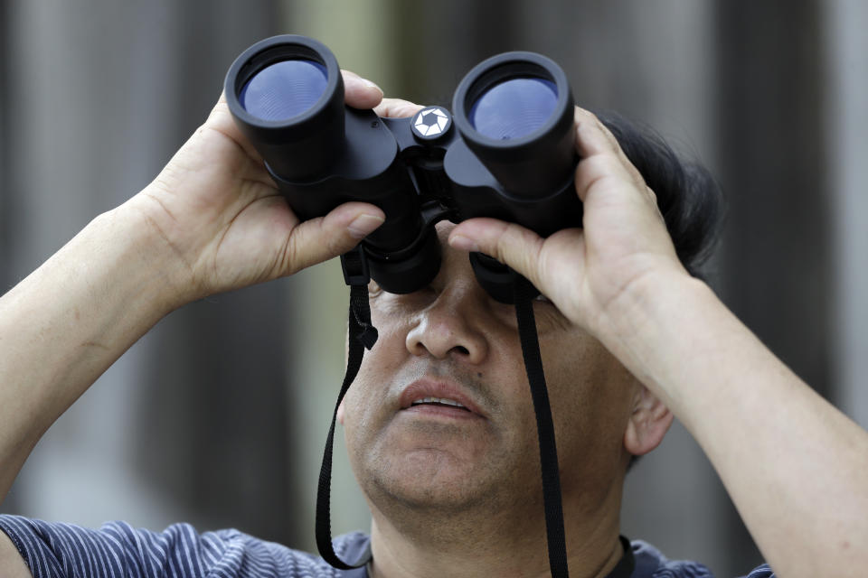 Ross Patacue uses binoculars to view a pair of bald eagles Wednesday, April 5, 2017, in Milpitas, Calif. The pair has nested on a tree top at an elementary school in Milpitas. Long endangered bald eagles are making a comeback in the San Francisco Bay Area. The local and national eagle boom is the pay-off for decades of environmental investment. Fifty years ago, the bird seemed destined to become a memory until official protection and pesticide restrictions were issued. (AP Photo/Marcio Jose Sanchez)