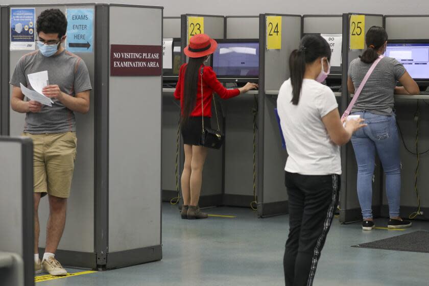 WESTMINSTER, CA - AUGUST 13: Clients observe social distancing while giving written driving test at DMV on Thursday, Aug. 13, 2020 in Westminster, CA. (Irfan Khan / Los Angeles Times)