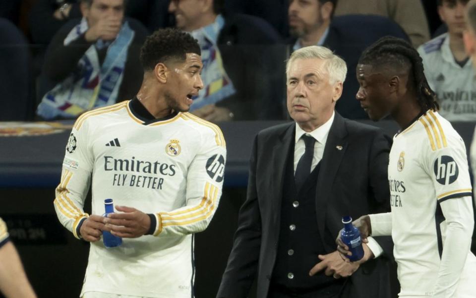 Real Madrid coach Carlo Ancelotti talks to Jude Bellingham and Eduardo Camavinga of Real Madrid during the UEFA Champions League quarter-final first leg between Real Madrid CF and Manchester City at Estadio Santiago Bernabeu on April 9, 2024 in Madrid, Spain.