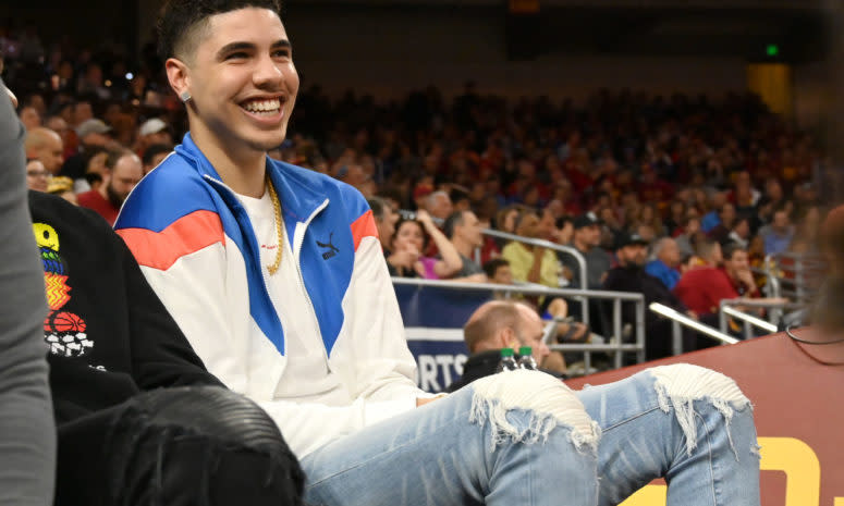 Charlotte Hornets guard LaMelo Ball on the sideline of a college game.