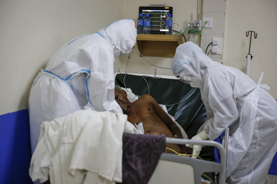 Medical workers attend to a coronavirus patient in the intensive care unit of an isolation and treatment center for those with COVID-19 in Machakos, south of the capital Nairobi, in Kenya Tuesday, Nov. 3, 2020. As Africa is poised to surpass 2 million confirmed coronavirus cases it is Kenya's turn to worry the continent with a second surge in infections well under way. (AP Photo/Brian Inganga)