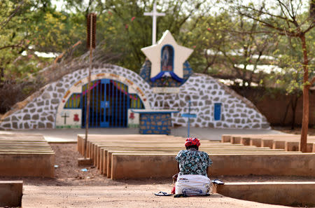 A woman prays near a statue of Virgin Mary outside the cathedral of Our Lady of Kaya in the city of Kaya, Burkina Faso May 16, 2019. REUTERS/Anne Mimault