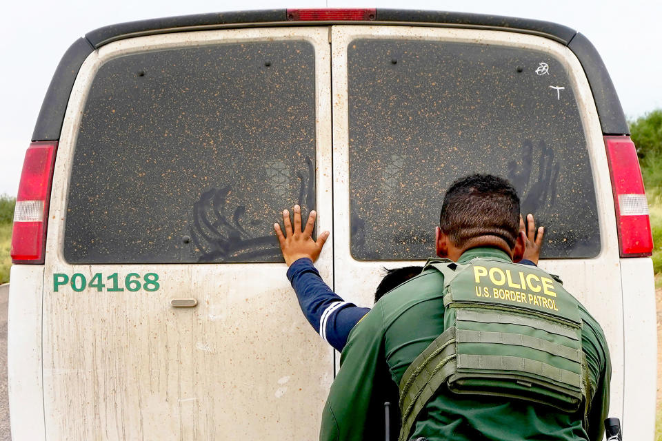 An immigrant is searched before transport after being apprehended by US Border Patrol agents at the base of the Baboquivari Mountains near Sasabe, Arizona, on Sept. 8, 2022.