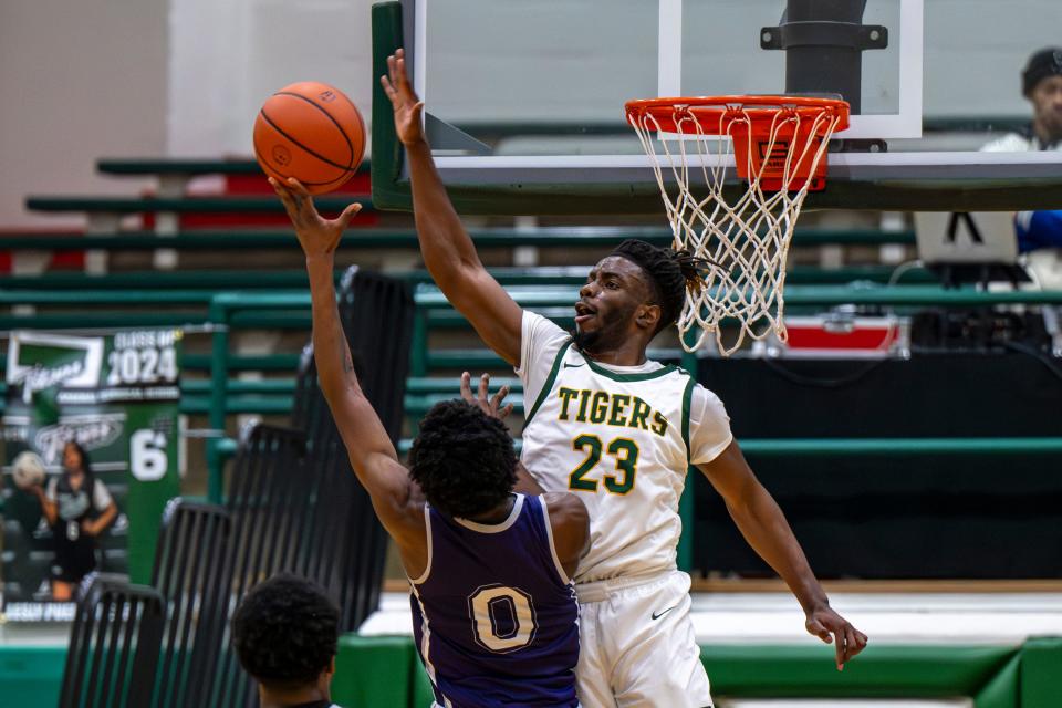 Indianapolis Crispus Attucks High School senior Jacson Payton (23) attempts to block a shot by Indianapolis Washington High School senior Jordan Stratton (0) during the first half of an Indianapolis Boys Basketball Tournament semi-final game, Saturday, Jan. 20, 2024, at Arsenal Tech High School.