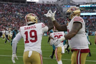 San Francisco 49ers wide receiver Deebo Samuel (19) celebrates his touchdown with offensive tackle Trent Williams, right, during the second half of an NFL football game against the Jacksonville Jaguars, Sunday, Nov. 12, 2023, in Jacksonville, Fla. (AP Photo/John Raoux)