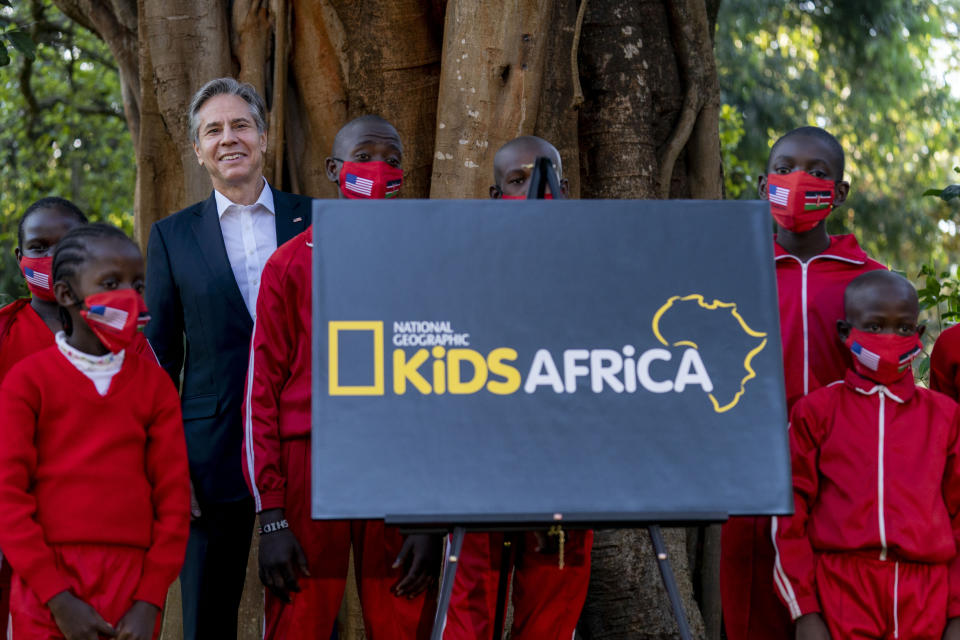 Secretary of State Antony Blinken poses for photographs with members of National Geographic Kids Africa after they unveil their new logo during a visit to the Karura Forest in Nairobi, Kenya, Wednesday, Nov. 17, 2021. Blinken is on a five day trip to Kenya, Nigeria, and Senegal. (AP Photo/Andrew Harnik, Pool)