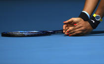 Japan's Naomi Osaka picks up a moth from the court during her second round singles match against China's Zheng Saisai at the Australian Open tennis championship in Melbourne, Australia, Wednesday, Jan. 22, 2020. (AP Photo/Andy Brownbill)