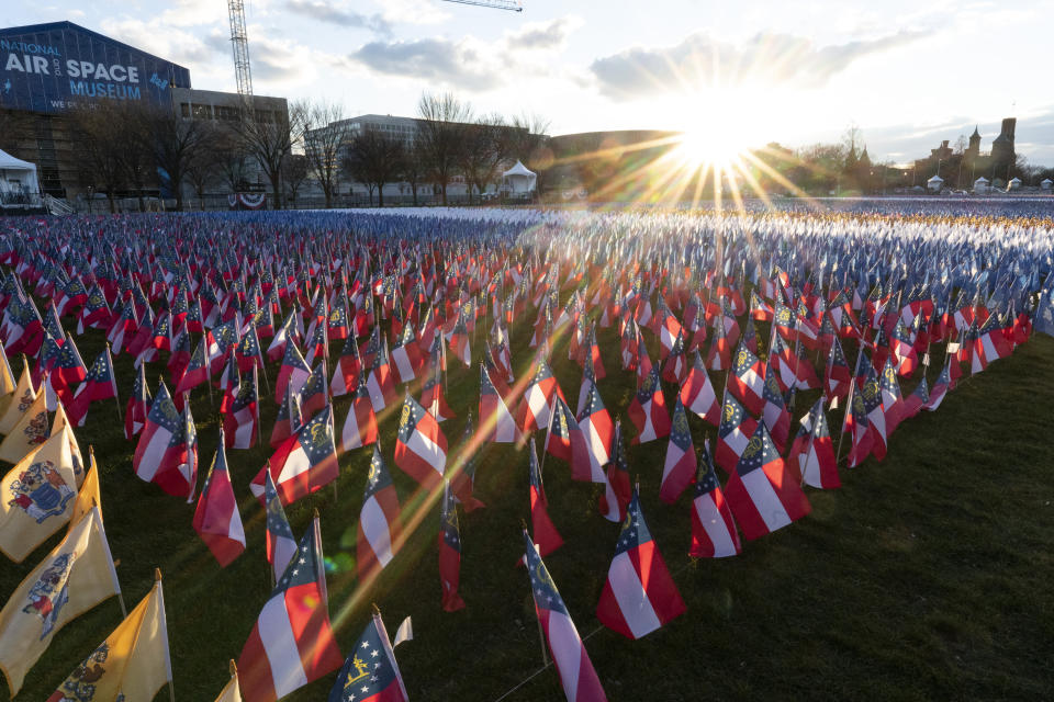 Un 'campo de banderas' se desplegó a lo largo del 'National Mall' de Washington DC en representación de los estadounidenses que no podrán asistir a la toma de poder del demócrata Joe Biden. Una inaguración atípica en medio de una pandemia mortal y por el gigantesco operativo de seguridad inédito tras los sucesos protagonizados por los seguidores de Trump en pasado 6 de enero. (AP Photo/Alex Brandon)