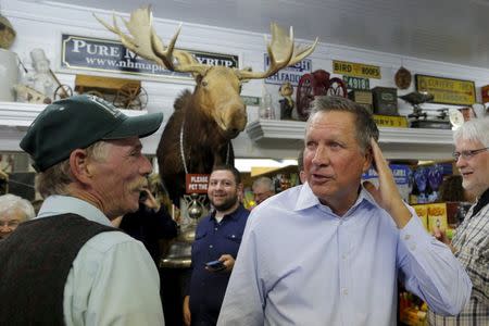 Owner Jim Fadden escorts Republican presidential candidate and Ohio Governor John Kasich (L) through Fadden's General Store in North Woodstock, New Hampshire October 14, 2015, during a multi-day campaign bus tour through the state. REUTERS/Brian Snyder