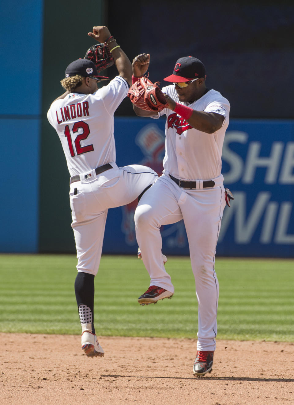 Cleveland Indians' Francisco Lindor and Yasiel Puig celebrate the Indians 2-0 win over the Texas Rangers at the end of the first game of a baseball doubleheader in Cleveland, Wednesday, Aug. 7, 2019. (AP Photo/Phil Long)