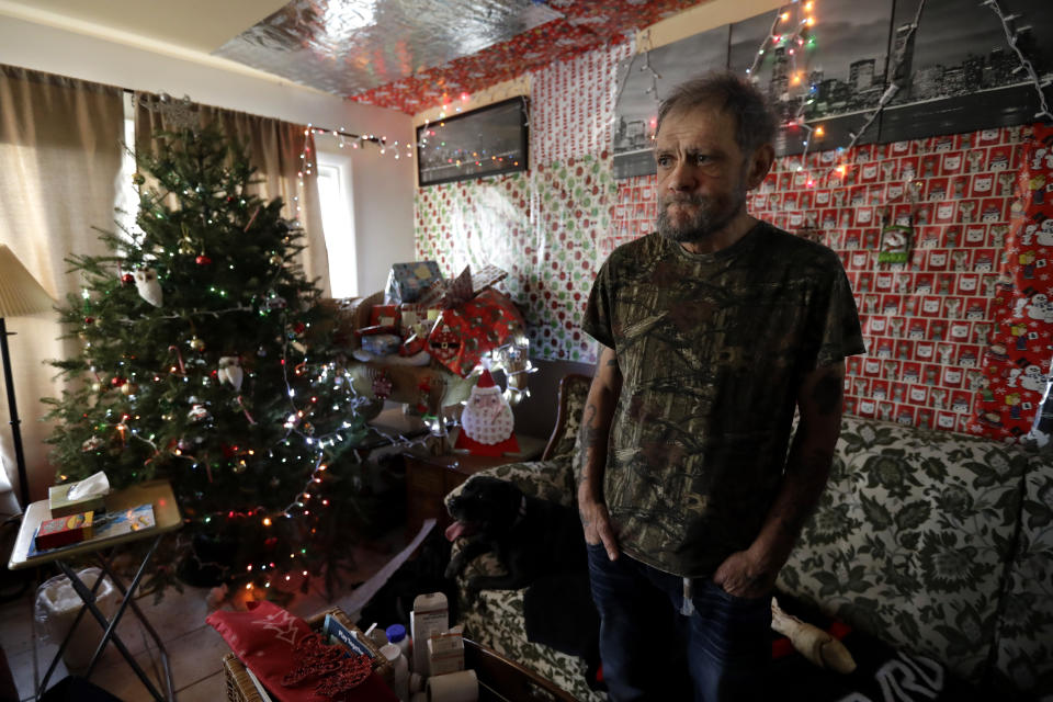 In this Friday, Dec. 20, 2019 photo, Bobby Goldberg stands in the living room at his home in suburban Chicago. Goldberg has filed a lawsuit claiming he was abused more than 1,000 times in multiple states and countries by the late Donald McGuire, a prominent American Jesuit priest who had close ties to Mother Teresa. (AP Photo/Nam Y. Huh)