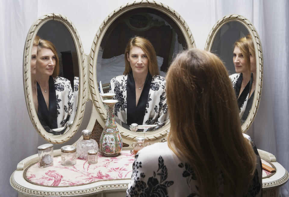 A woman sitting at her vanity mirror
