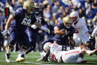 Navy quarterback Tai Lavatai, center right, is sacked by Houston defensive lineman Atlias Bell (17) and defensive lineman Nelson Ceaser (9) during the first half of an NCAA college football game, Saturday, Oct. 22, 2022, in Annapolis, Md. (AP Photo/Julio Cortez)