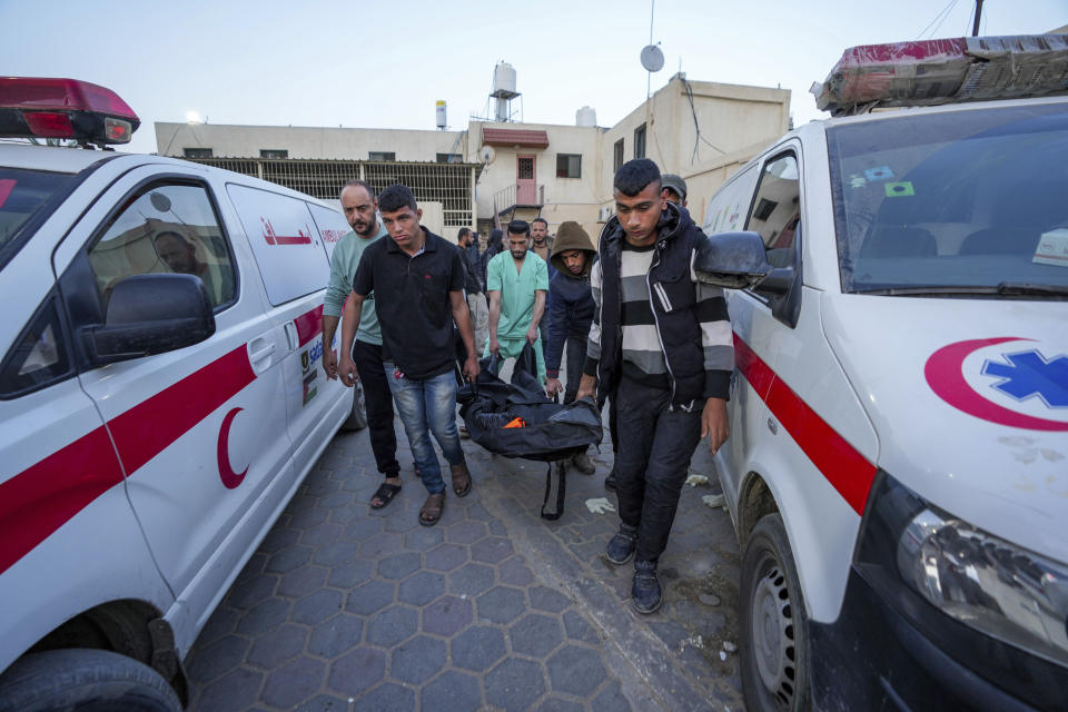 Palestinians carry the body of a World Central Kitchen worker at Al Aqsa hospital in Deir al-Balah, Gaza Strip, Tuesday, April 2, 2024. World Central Kitchen, an aid group, says an Israeli strike that hit its workers in Gaza killed at least seven people, including several foreigners. (AP Photo/Abdel Kareem Hana)