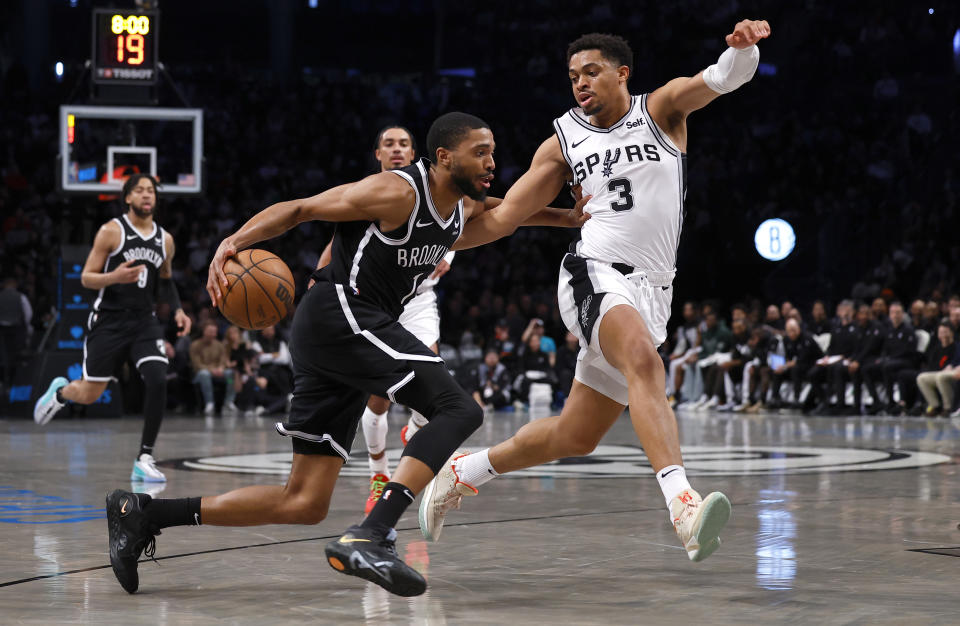 Brooklyn Nets forward Mikal Bridges drives to the basket against San Antonio Spurs forward Keldon Johnson (3) during the first half of an NBA basketball game, Saturday, Feb. 10, 2024, in New York. (AP Photo/Noah K. Murray)