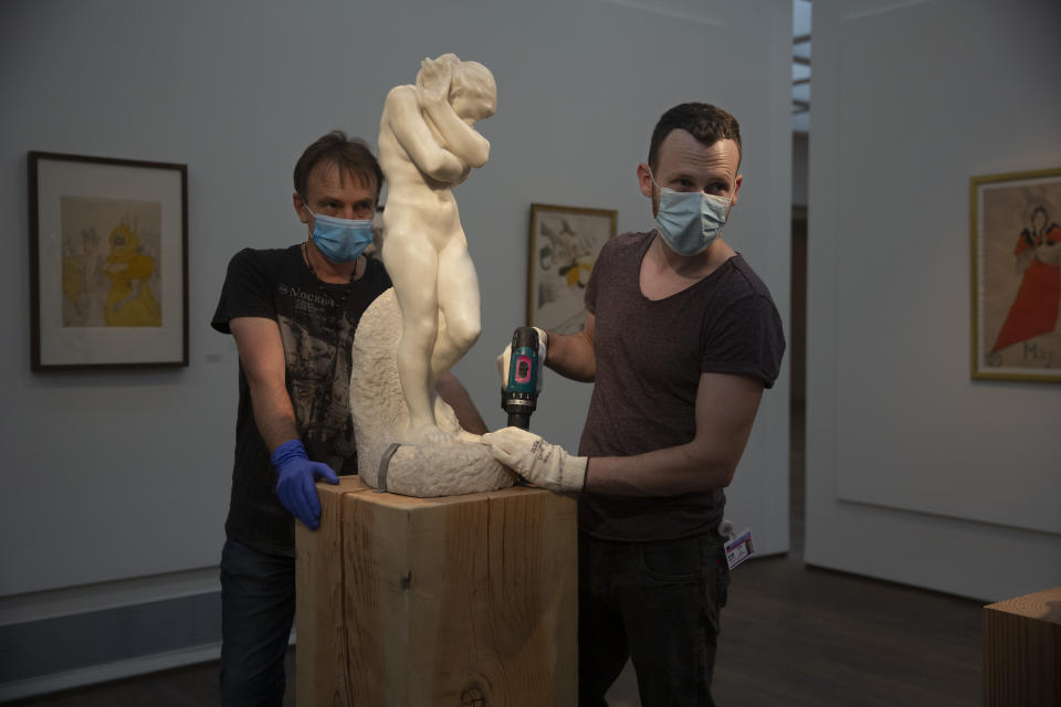 Workers in the Israel Museum place Auguste Rodin's "Eve" on a pedestal, following five months of closure due to the coronavirus pandemic, in Jerusalem, Tuesday, Aug. 11, 2020. The Israel Museum, the country's largest cultural institution, is returning the priceless Dead Sea scrolls and other treasured artworks to its galleries ahead of this week's reopening to the public. (AP Photo/Maya Alleruzzo)