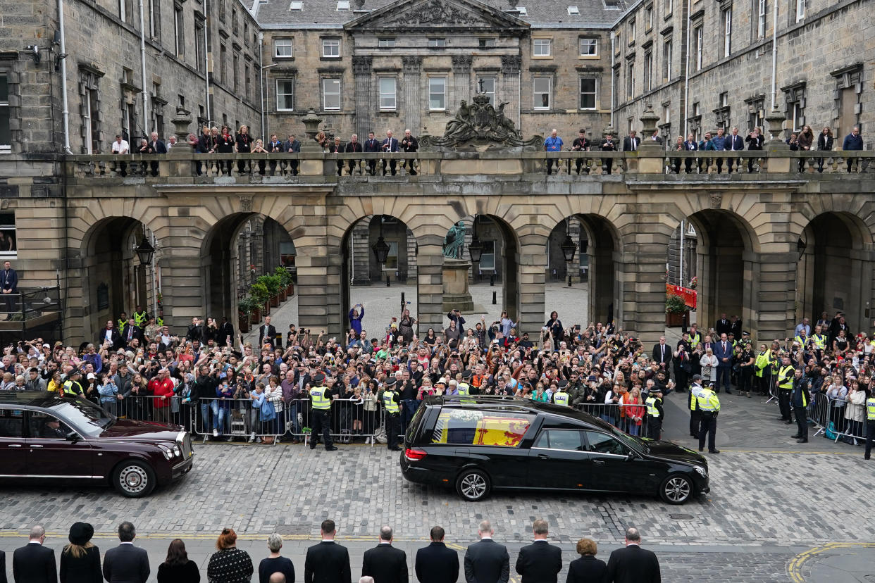 Crowds watch the cortege carrying the coffin of the late Queen Elizabeth II by Mercat Cross on September 11, 2022 in Edinburgh.