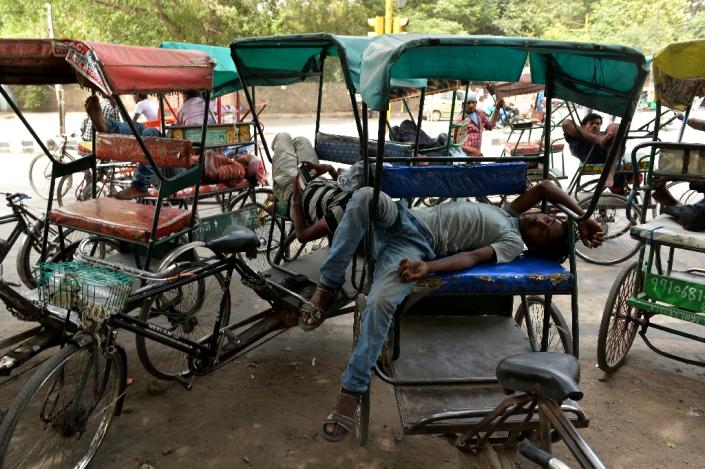 Cycle rickshaw riders sleep during the heatwave in New Delhi on May 28, 2015 (AFP Photo/Chandan Khanna)