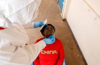 A health worker takes a swab from a woman during a mass testing in an effort to stop the spread of the coronavirus disease (COVID-19) in the Kibera slum of Nairobi