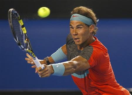 Rafael Nadal of Spain hits a return to Bernard Tomic of Australia during their men's singles match at the Australian Open 2014 tennis tournament in Melbourne January 14, 2014. REUTERS/Petar Kujundzic