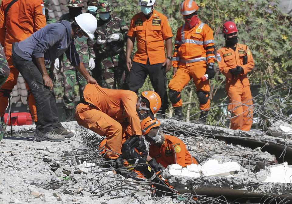 In this Tuesday, Aug. 7, 2018, photo, rescuers carry the body of an earthquake victim recovered from the collapsed Jabal Nur mosque in North Lombok, Indonesia. (AP Photo/Tatan Syuflana)