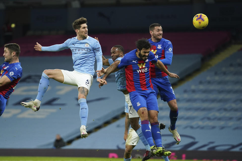 Manchester City's John Stones, centre left, heads the ball to score his side's opening goal during an English Premier League soccer match between Manchester City and Crystal Palace at the Etihad Stadium in Manchester, England, Sunday Jan.17, 2021. (AP Photo/Dave Thompson, Pool)