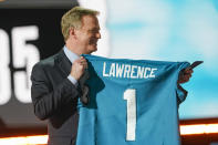 Roger Goodell, comisionado de la NFL, sostiene un jersey con el apellido de Trevor Lawrence, reclutado por los Jaguars de Jacksonville como la primera selección del draft, el jueves 29 de abril de 2021, en Cleveland (AP Foto/Tony Dejak)
