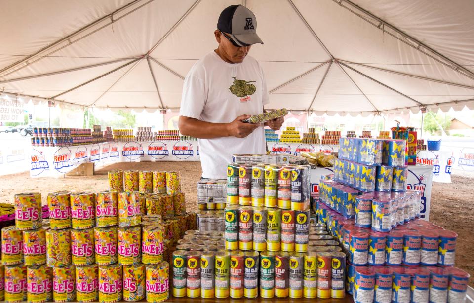 Thompson Begay looks over the selection of fireworks at a Red Hot Fireworks stand in Gilbert on Thursday, June 26, 2014. The stand, at the corner of Lindsay and Baseline roads, opened Thursday and expects to be completely sold out by July 4.