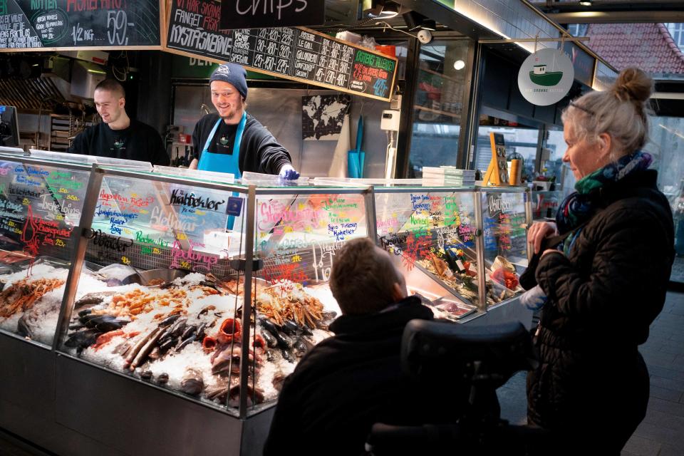 Customers are pictured at the fishmarket in Torvehallerne in Copenhagen on February 1, 2022, as Denmark becomes the first EU country to lift coronavirus restrictions despite record case numbers, citing its high vaccination rates and the lesser severity of Omicron variant. - February 1, 2022 de facto lifts all domestic restrictions, including the use of a vaccine pass, mask-wearing and early closings for bars and restaurants. Some border measures will remain in place for another four weeks, including tests and/or quarantine depending on travellers' immunity status. - Denmark OUT (Photo by Liselotte Sabroe / Ritzau Scanpix / AFP) / Denmark OUT (Photo by LISELOTTE SABROE/Ritzau Scanpix/AFP via Getty Images)