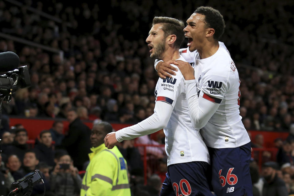 Liverpool's Adam Lallana, left, celebrates with Liverpool's Trent Alexander-Arnold after scoring his side's opening goall during the English Premier League soccer match between Manchester United and Liverpool at the Old Trafford stadium in Manchester, England, Sunday, Oct. 20, 2019. (AP Photo/Jon Super)