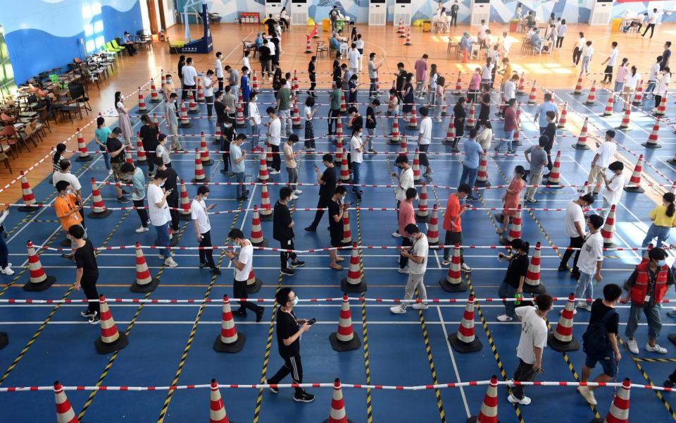 Workers line up for mass coronavirus tests in a gym n Wuhan -  CHINATOPIX