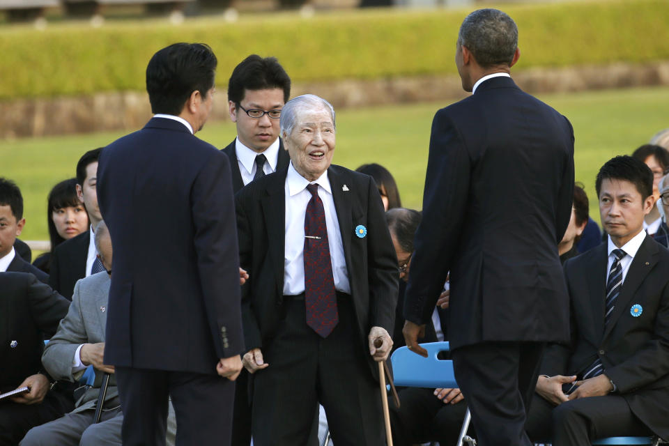 FILE - In this May 27, 2016, file photo, Japanese atomic bomb survivor and Hiroshima Prefectural Confederation of A-bomb Sufferers Organization Chairman Sunao Tsuboi, center, talks with then U.S. President Barack Obama, right, accompanied by then Japanese Prime Minister Shinzo Abe, left, at Hiroshima Peace Memorial Park in Hiroshima, western, Japan. Tsuboi, a survivor of the Hiroshima atomic bombing, who made opposing nuclear weapons the message of his life, including in a meeting with then President Obama in 2016, has died. He was 96.(AP Photo/Shuji Kajiyama, File)