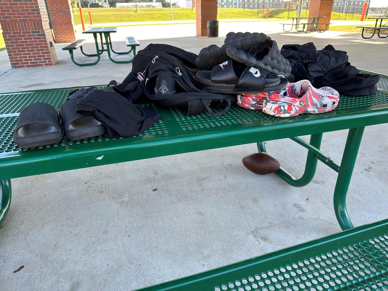 Shoes, a football and other items were left behind by panicked victims and bystanders of the mass shooting Nov. 27, 2022, at a Florida A&M University outdoor basketball court. Police gathered up the belongings and left them on a picnic table.