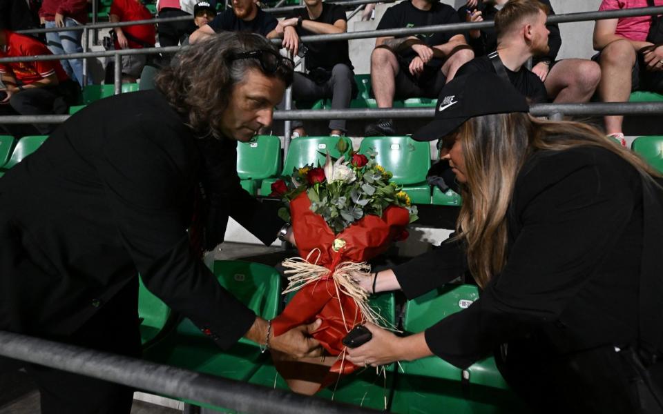 Representatives from Liverpool and AC Milan have put flowers on the seat of the Liverpool fan who passed away