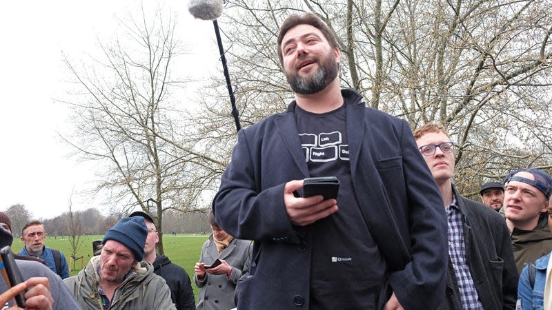 Carl Benjamin at a 2018 rally that included him taking pictures behind the “kek” flag, which is a major symbol for the alt right and white nationalists, according to the Southern Poverty Law Center.