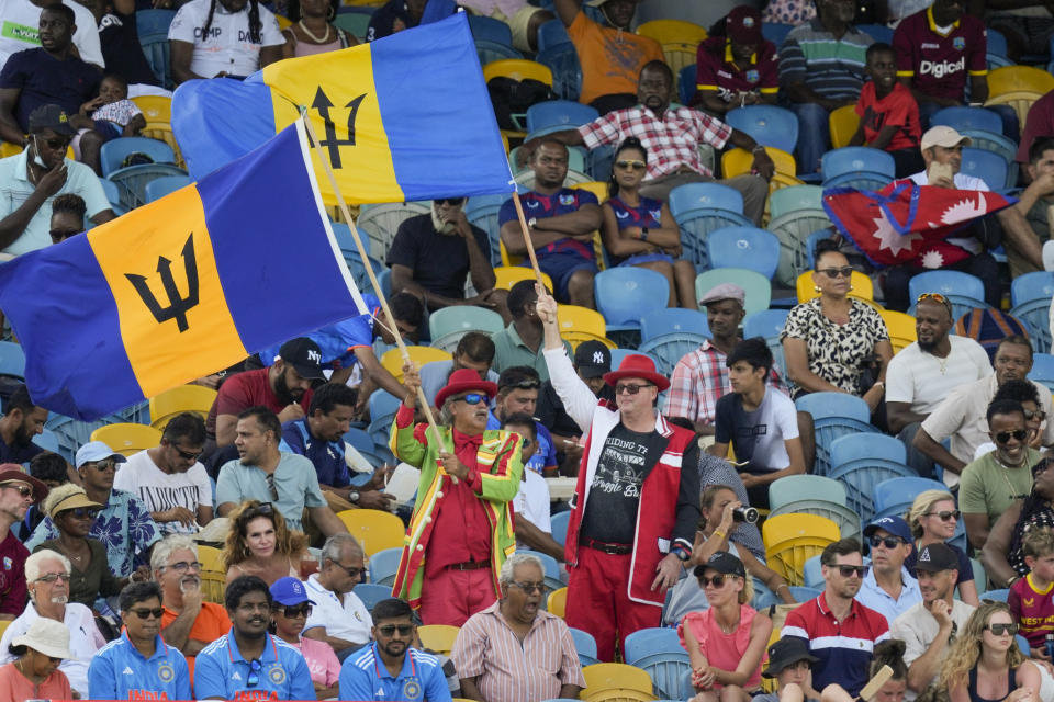 Fans wave flags of Barbados during the first ODI cricket match between India and West Indies at Kensington Oval in Bridgetown, Barbados, Thursday, July 27, 2023. (AP Photo/Ricardo Mazalan)