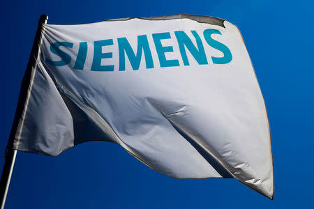 FILE PHOTO: A flag with the logo of German technology firm Siemens is seen at its branch in Berlin, Germany, May 30, 2014. REUTERS/Thomas Peter/File Photo