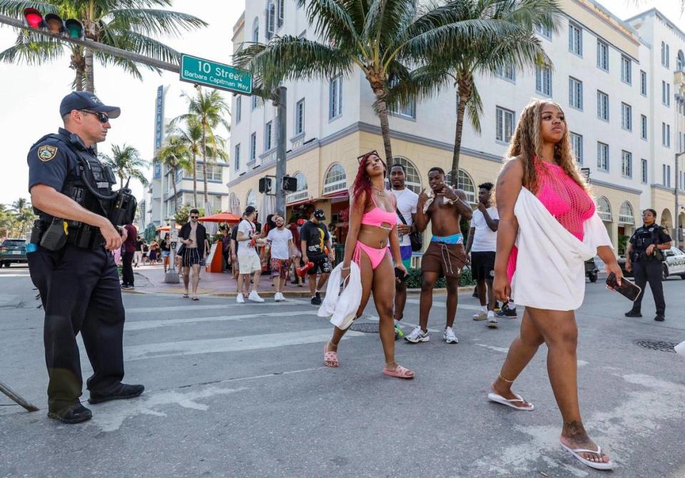 Miami Beach police officer C. Olloqui stands watch on Ocean Drive and 10th Street during spring break on Miami Beach, Florida on Saturday, March 16, 2024.