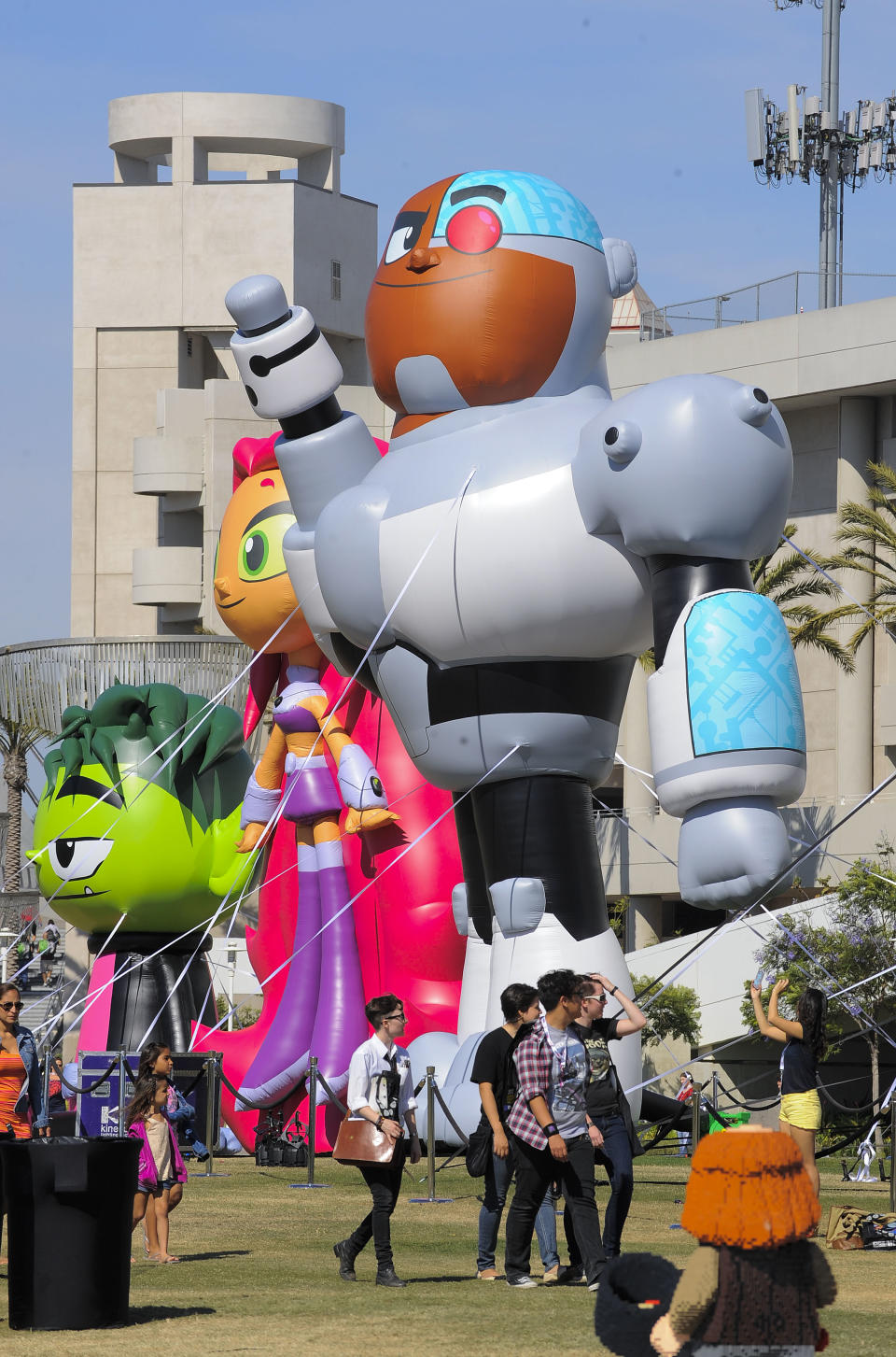 Fans walks past blow up Team Titans figures outside the San Diego Convention Center as they head to the Preview Night event on Day 1 of the 2013 Comic-Con International Convention on Wednesday, July 17, 2013, in San Diego. (Photo by Denis Poroy/Invision/AP)