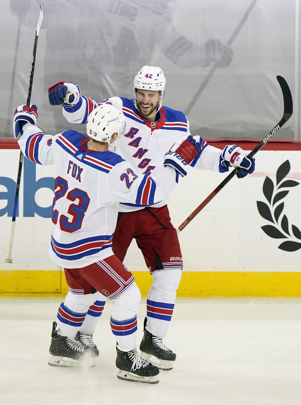 New York Rangers defenseman Brendan Smith (42) celebrates with Rangers defenseman Adam Fox (23) after scoring a goal during the third period of an NHL hockey game against the New Jersey Devils, Thursday, March 4, 2021, in Newark, N.J. (AP Photo/Kathy Willens)