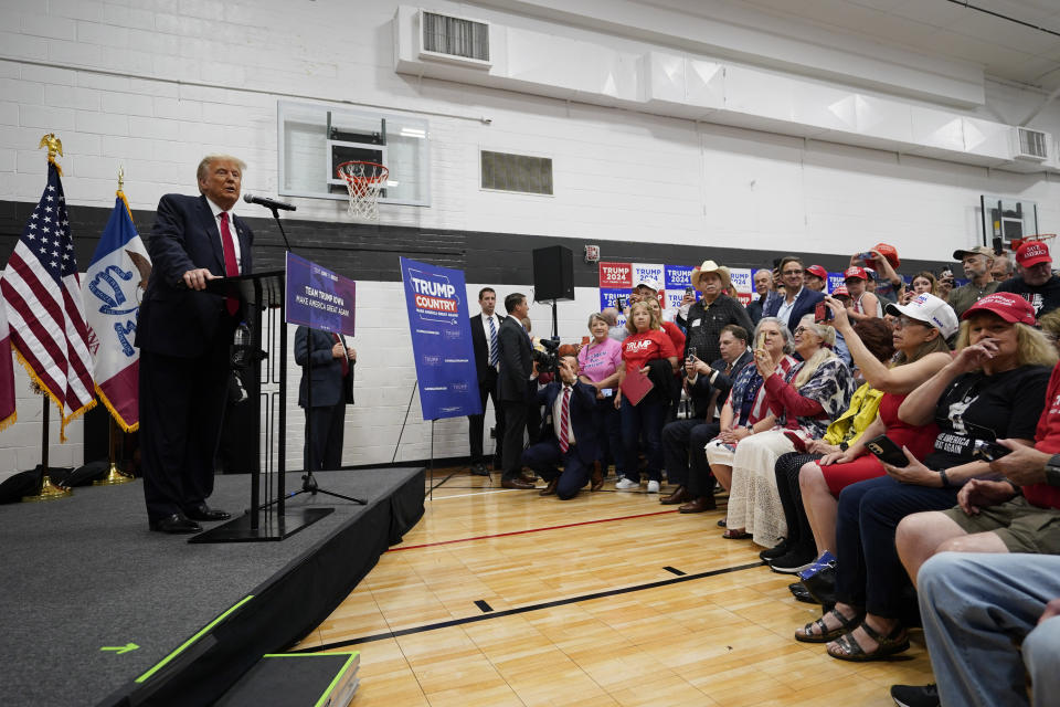 Former President Donald Trump, left, visits with campaign volunteers at the Grimes Community Complex Park, Thursday, June 1, 2023, in Des Moines, Iowa. (AP Photo/Charlie Neibergall)