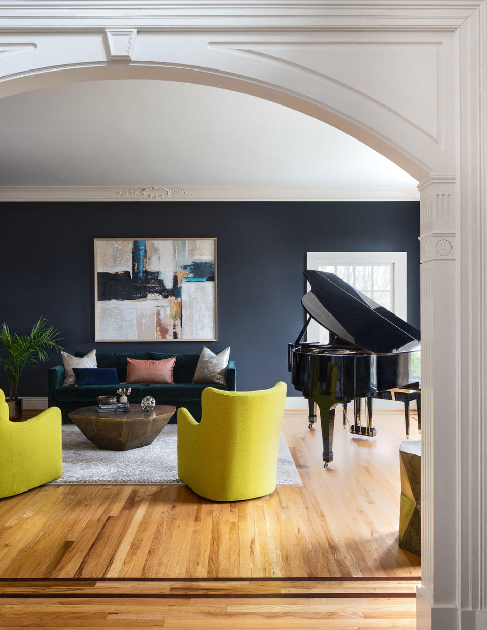 living room with blue walls, grand piano, yellow accent chairs