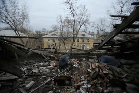 Workers repair a gas pipeline in a building after it was damaged by recent shelling in the western part of Donetsk, eastern Ukraine, November 27, 2014. REUTERS/Antonio Bronic