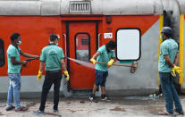 Workers wash and disinfect trains coaches at a rail yard, as a measure to prevent the spread of coronavirus in New Delhi.