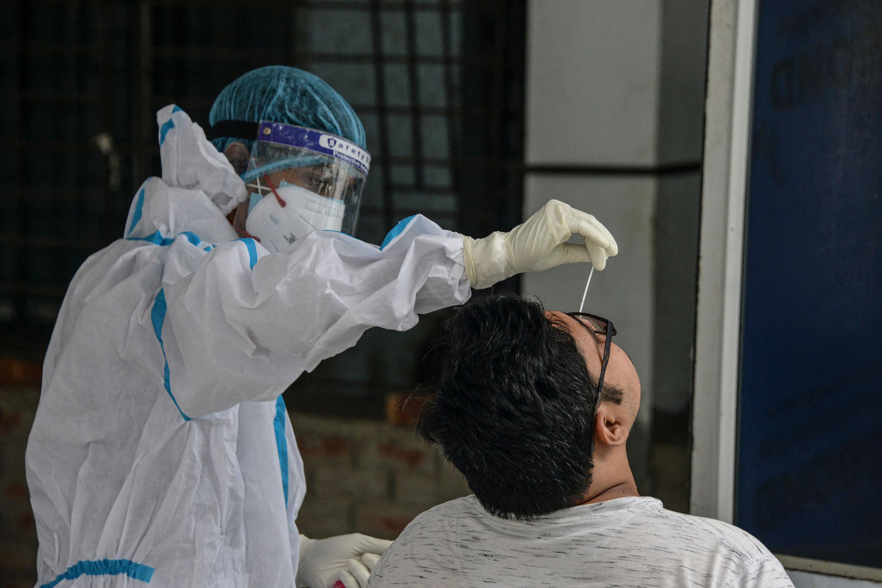 A health worker collects a swab sample for a RT-PCR COVID-19 test at the North Bengal Medical college and hospital on the outskirts of Siliguri on June 8, 2021