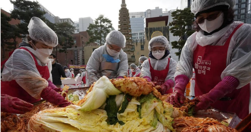 幾位志工們齊聚在韓國首爾的一座寺廟內醃製泡菜，泡菜最後會捐贈給有需要的附近居民。（圖／達志／美聯社）