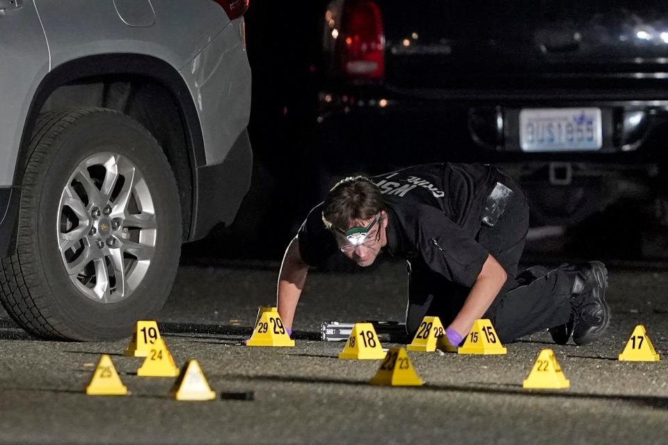 A Washington State Patrol Crime Lab worker looks at evidence markers in the early morning hours of Friday, Sept. 4, 2020, in Lacey, Wash.